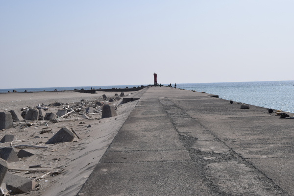 赤羽根港の赤灯台のある堤防の根元から先端を撮った写真